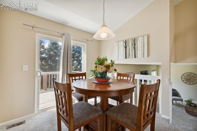 carpeted dining space featuring baseboards, vaulted ceiling, and visible vents