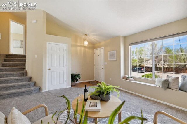 6248 Montero Cir, Colorado Springs, CO 80915 - carpeted living room featuring baseboards, vaulted ceiling, and stairway