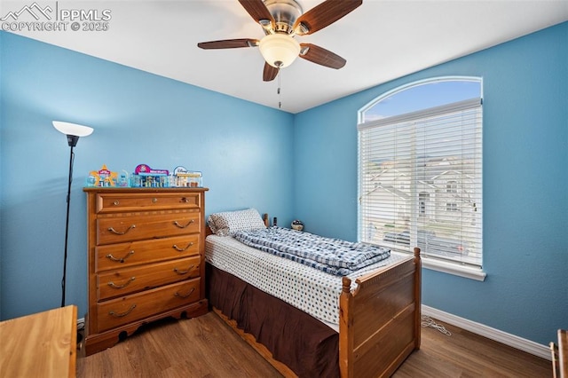 bedroom with baseboards, a ceiling fan, and dark wood finished floors