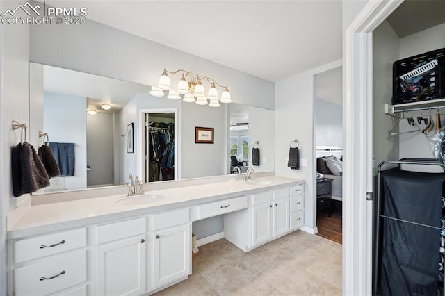 full bathroom with tile patterned flooring, double vanity, a sink, and a spacious closet