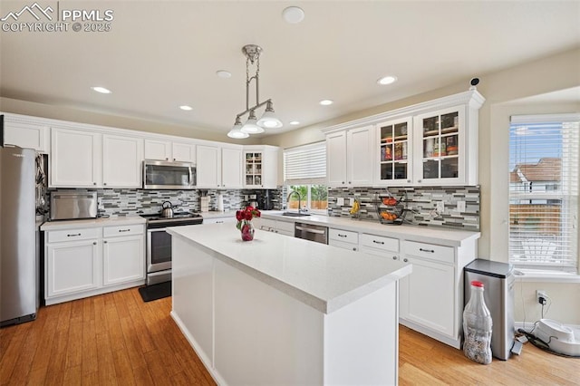 kitchen featuring appliances with stainless steel finishes, tasteful backsplash, and white cabinets