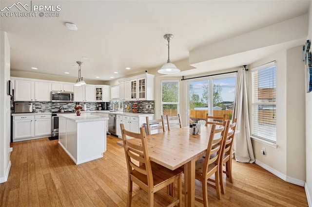 dining space with recessed lighting, baseboards, and light wood finished floors