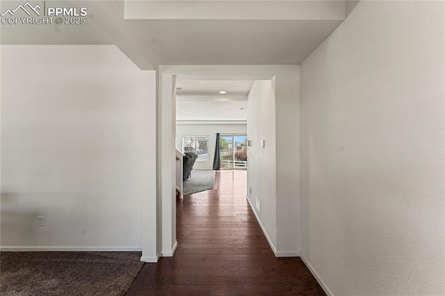 corridor with baseboards and dark wood-style floors