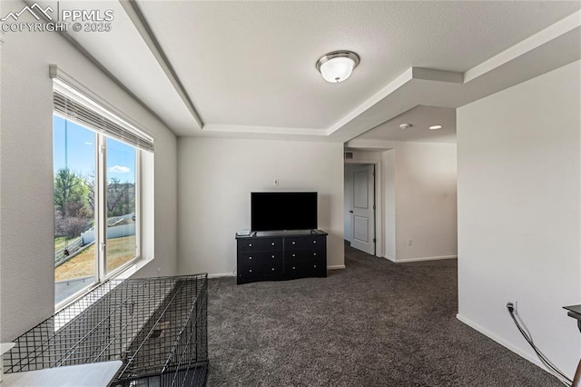 interior space with a tray ceiling, baseboards, and carpet flooring