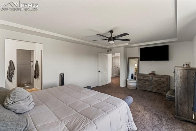 carpeted bedroom with connected bathroom, a tray ceiling, visible vents, and ceiling fan