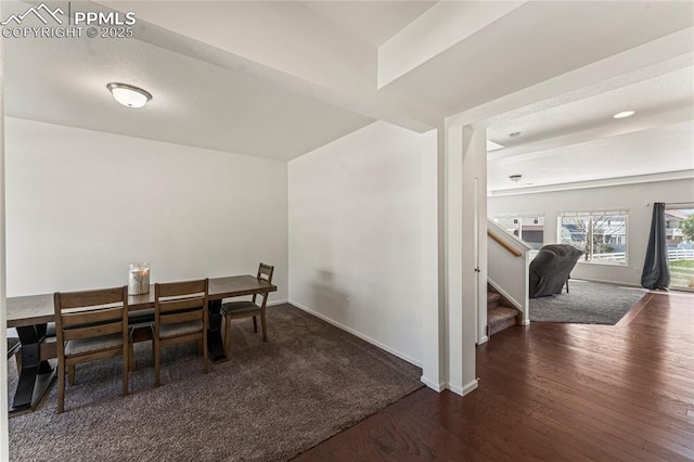 dining space with baseboards, wood finished floors, and stairway