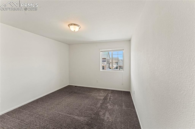 carpeted spare room featuring baseboards