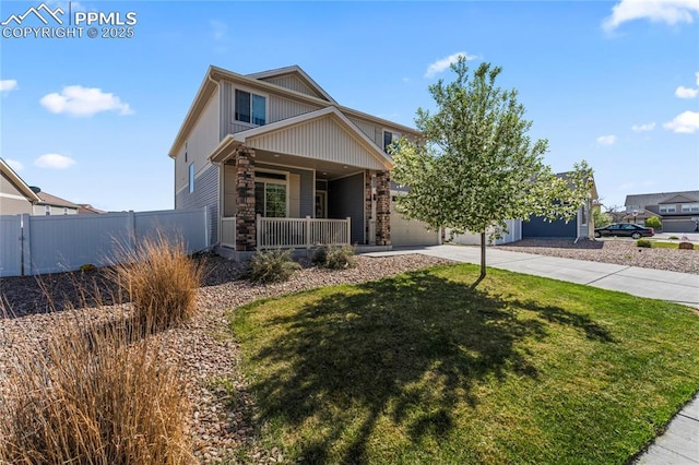 view of front facade with a porch, driveway, fence, a front lawn, and stone siding