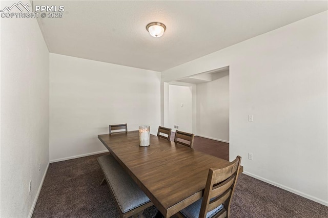 carpeted dining room featuring baseboards