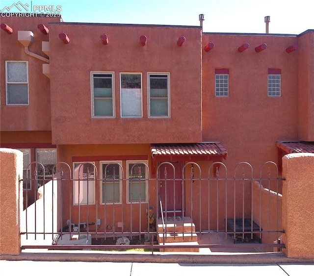 view of front of home with a gate and stucco siding