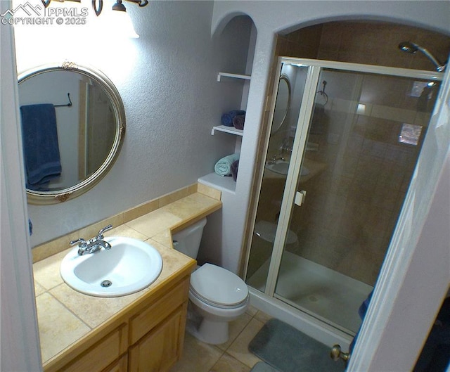full bathroom with vanity, tile patterned floors, a stall shower, and toilet