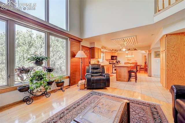 620 Coveglen Ct, Colorado Springs, CO 80906 - living area featuring visible vents, a high ceiling, light wood-style flooring, and a wealth of natural light