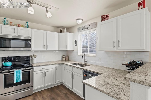 kitchen featuring appliances with stainless steel finishes, a sink, white cabinets, and dark wood-style floors