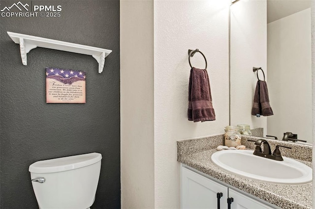 half bath featuring vanity and toilet