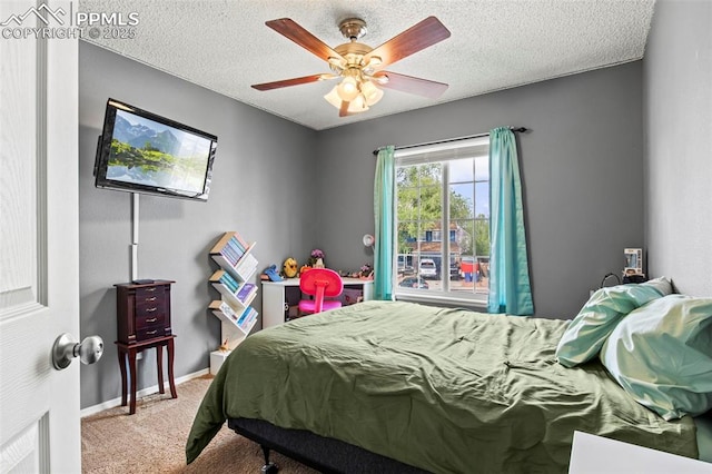 carpeted bedroom with a textured ceiling, ceiling fan, and baseboards