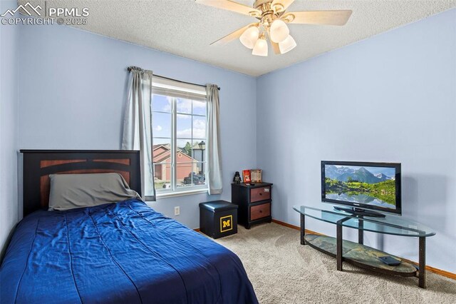 carpeted bedroom featuring baseboards, a textured ceiling, and a ceiling fan