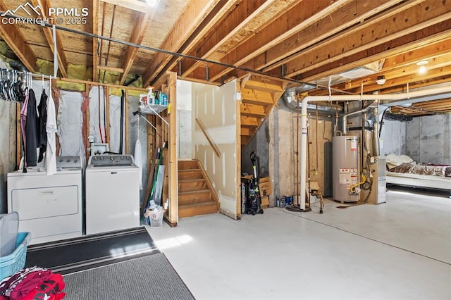 unfinished basement featuring gas water heater, washing machine and dryer, and stairway