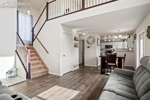 living room with stairway, dark wood finished floors, and baseboards