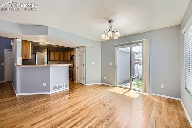 7824 Bengali Ln, Colorado Springs, CO 80923 - unfurnished dining area with baseboards, a notable chandelier, visible vents, and light wood-style flooring