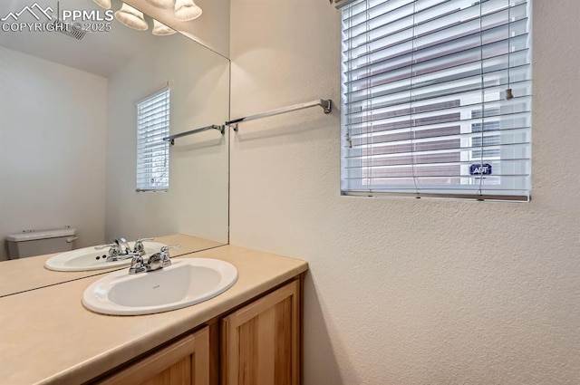 7824 Bengali Ln, Colorado Springs, CO 80923 - half bathroom with vanity, a textured wall, and toilet