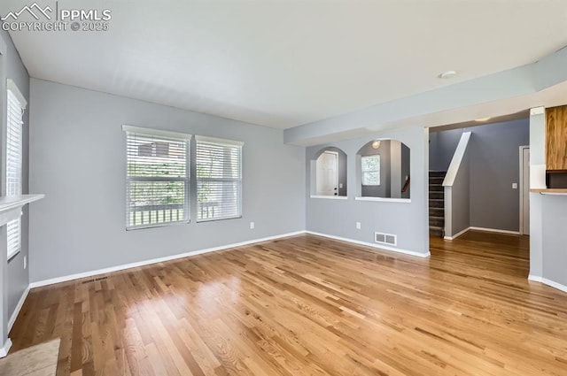 7824 Bengali Ln, Colorado Springs, CO 80923 - unfurnished living room with visible vents, baseboards, stairs, and light wood-type flooring