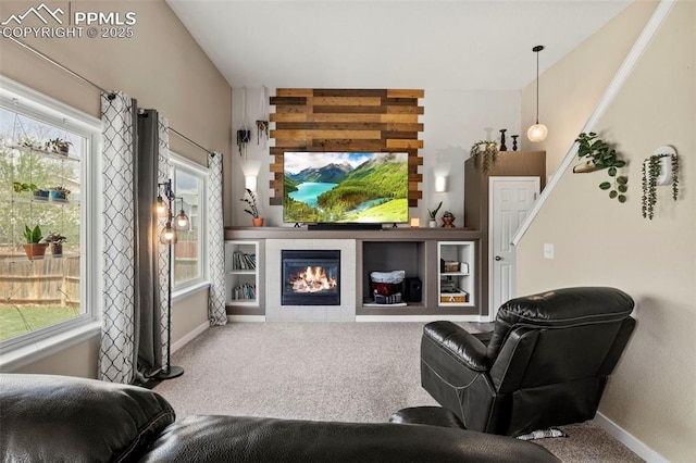 carpeted living area featuring baseboards and a tiled fireplace