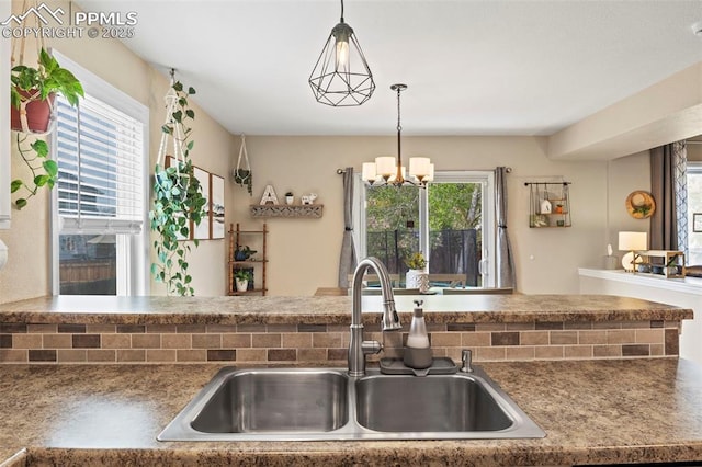 kitchen featuring a sink, a chandelier, healthy amount of natural light, and hanging light fixtures