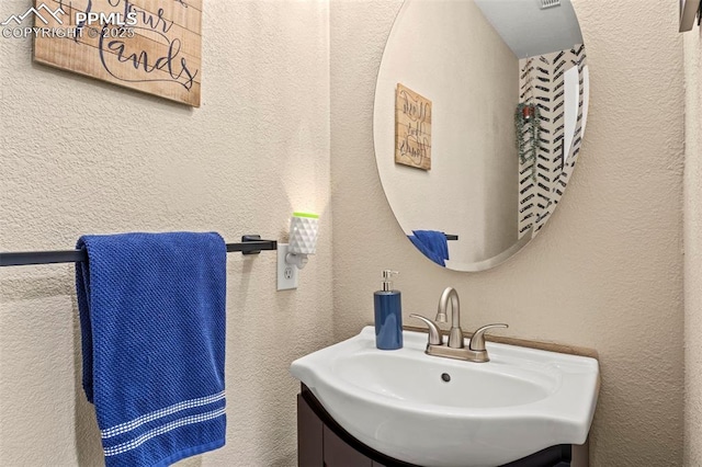 bathroom featuring vanity and a textured wall