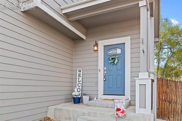 doorway to property featuring fence