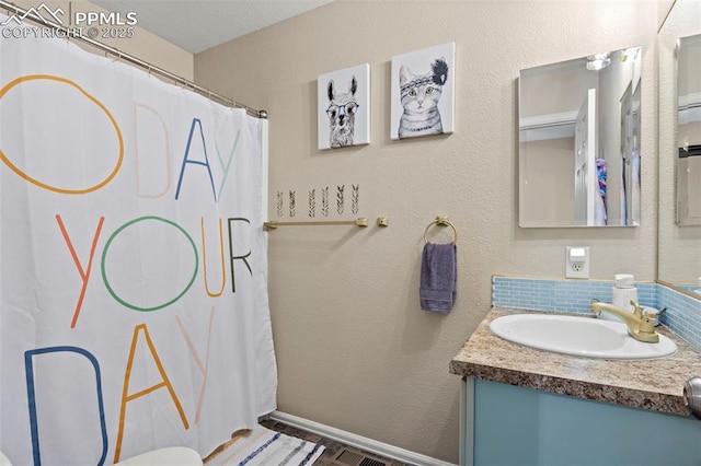 bathroom featuring vanity, curtained shower, and baseboards