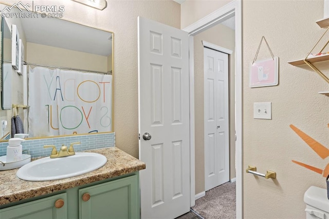 full bath featuring vanity, a textured wall, curtained shower, toilet, and tasteful backsplash