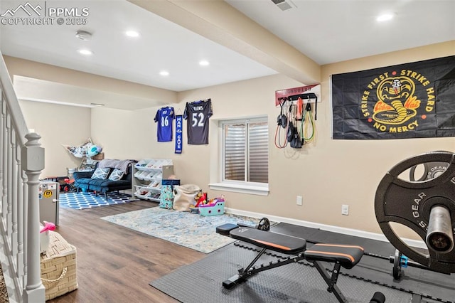 exercise room featuring recessed lighting, wood finished floors, and baseboards