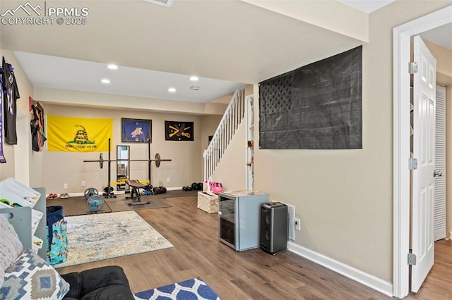 interior space with baseboards, wood finished floors, recessed lighting, and stairs