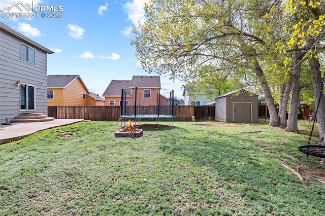 view of yard with a trampoline, a shed, an outbuilding, a patio, and entry steps