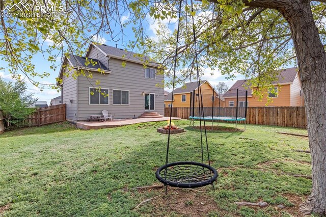 rear view of property with a trampoline
