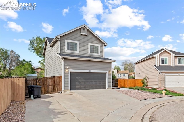 view of side of home featuring an attached garage, driveway, and fence