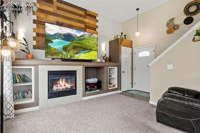 living area featuring carpet floors, a tiled fireplace, baseboards, and a towering ceiling