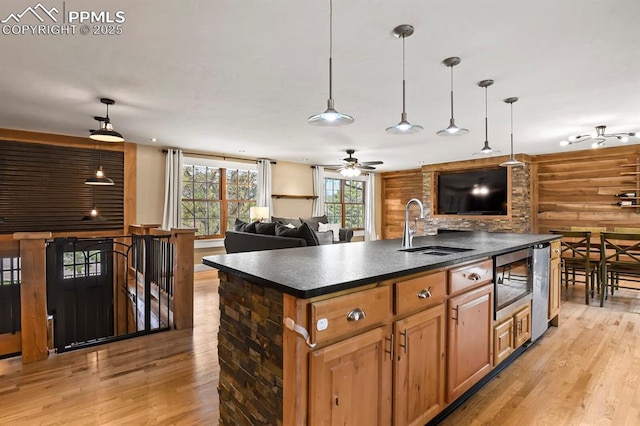 15 Newport Cir, Colorado Springs, CO 80906 - kitchen with dark countertops, open floor plan, a sink, and light wood-type flooring
