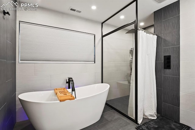 15 Newport Cir, Colorado Springs, CO 80906 - full bath with visible vents, tile walls, tiled shower, recessed lighting, and a soaking tub