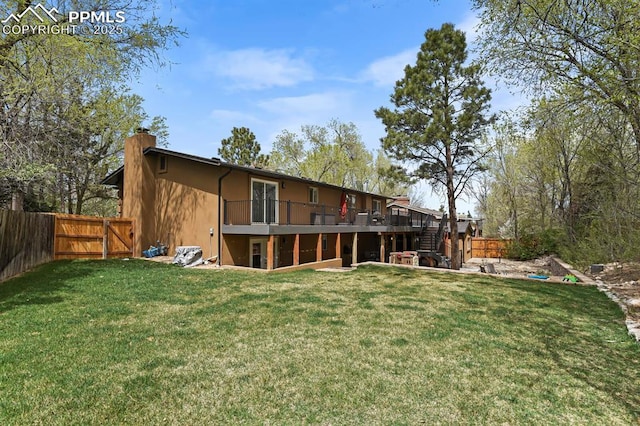 15 Newport Cir, Colorado Springs, CO 80906 - rear view of house featuring a chimney, a lawn, a wooden deck, and stairway