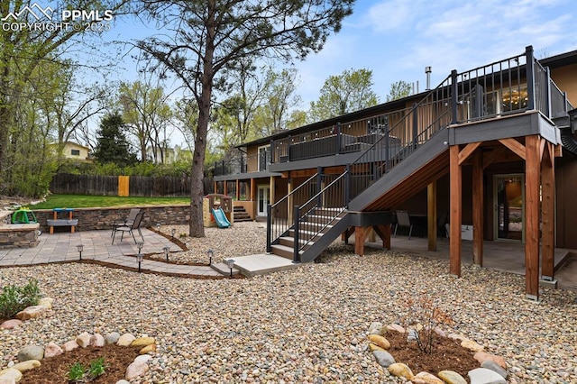 15 Newport Cir, Colorado Springs, CO 80906 - rear view of property featuring a wooden deck, fence, a patio area, an outdoor fire pit, and stairway