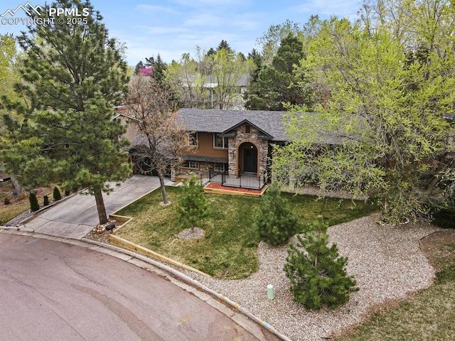 15 Newport Cir, Colorado Springs, CO 80906 - view of front of property with a front yard, stone siding, and concrete driveway