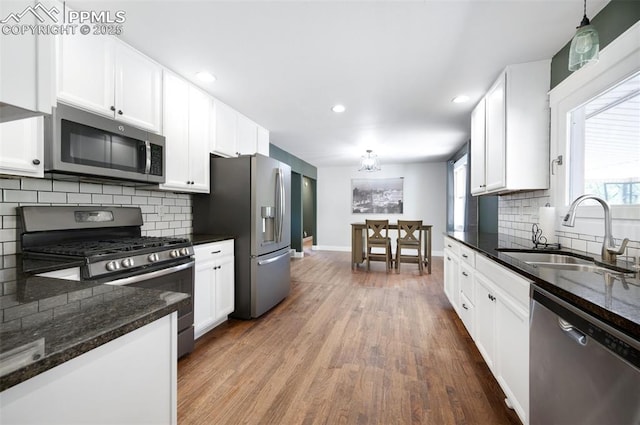 208 Davie Dr, Colorado Springs, CO 80911 - kitchen with a sink, wood finished floors, white cabinets, and stainless steel appliances