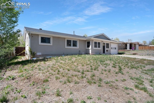 208 Davie Dr, Colorado Springs, CO 80911 - back of house with stucco siding, a garage, and fence