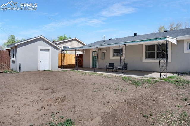 208 Davie Dr, Colorado Springs, CO 80911 - back of house with fence, an outbuilding, a patio area, and stucco siding