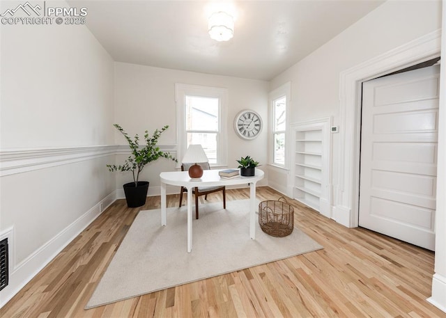 home office with baseboards and light wood-type flooring