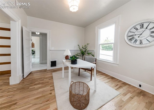 office space featuring baseboards, visible vents, and light wood-style floors