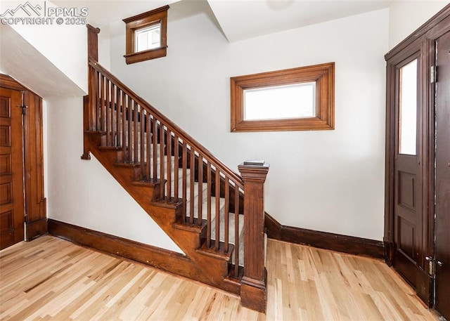 entryway featuring stairway, baseboards, and wood finished floors
