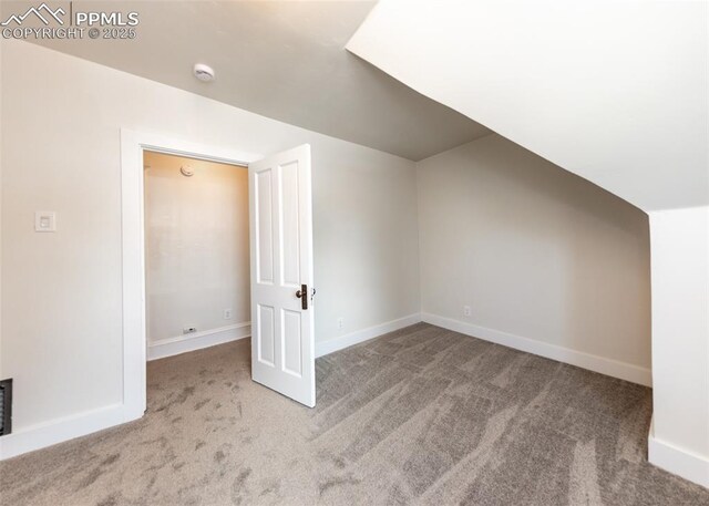 additional living space with carpet floors, baseboards, and lofted ceiling