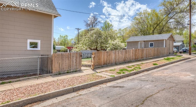 view of property exterior featuring roof with shingles and fence